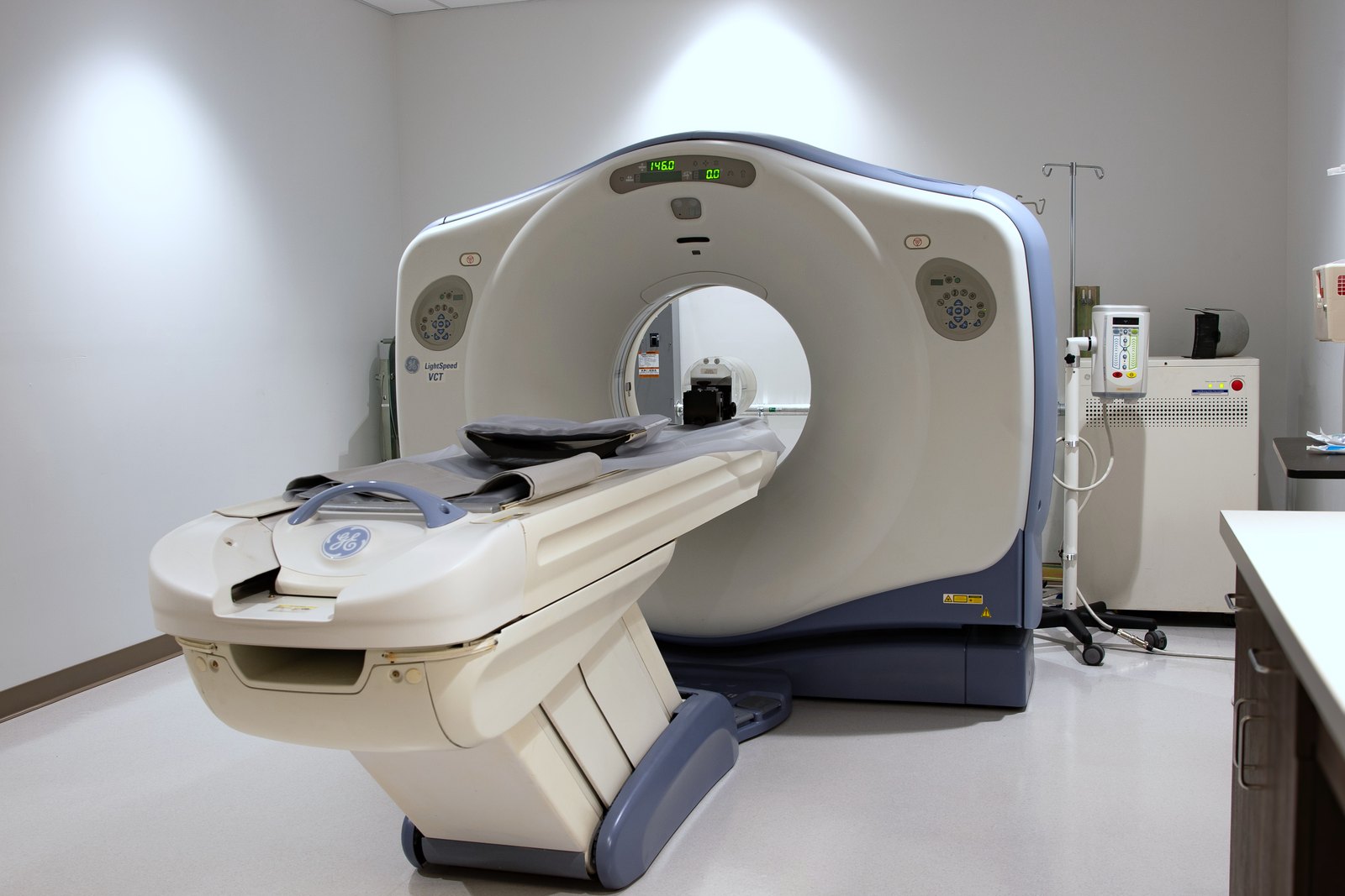 A CT scanner at El Mirage ER — the circular gantry with its patient couch extended, in an empty scanning room.